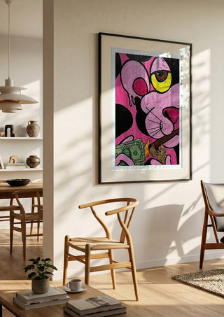 Capitalist Illusion by Bibi in a black frame in a bright dining room with wooden chairs