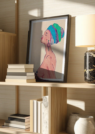 Melanin & Moonlight by Bibi in a dark frame on a wooden shelf beside books and a lamp
