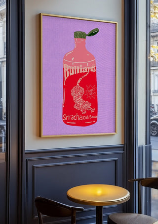 Sriracha chili sauce by Astrid Lind in an oak frame on a panelled café wall