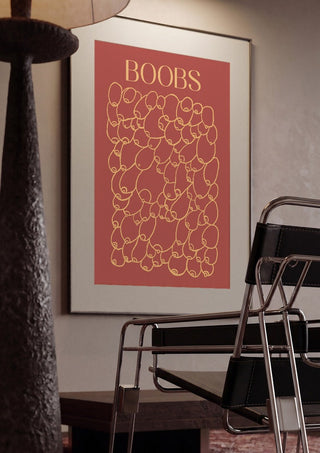 Boobs by Astrid Lind framed in a dim room beside a tubular steel chair