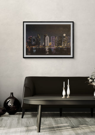 Doha by night by Dina in a black frame above a dark sofa with white candlesticks