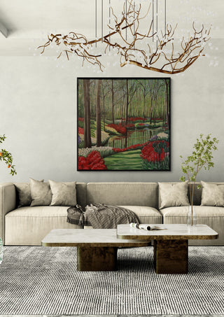 Spring by Dina in a black frame above a beige sofa under a branch chandelier