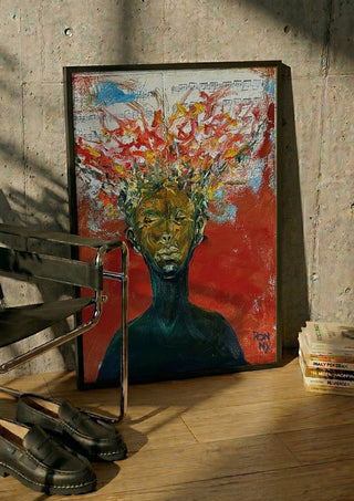The Sound by Ronny Simon in a black frame leaning against a concrete wall by a steel chair