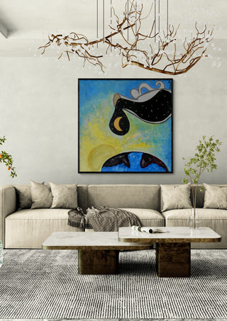 Day into night by A Sleepy Spirit Art in a black frame above a beige sofa under a branch chandelier