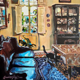 Kamra tal-pranzu bil-bitħa fl-isfond by Mariam De Giorgio — an ochre dining room with a china dresser, blue rug and a black cat by the courtyard door.