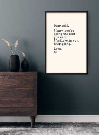 Dear Self Citat Plakat on a dark wall above a wooden dresser with decorative vases and dried grasses.