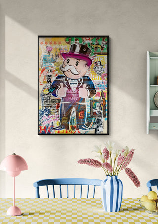 Framed Monopoly - Ricardo Noble artwork hanging on a wall above a dining table with flowers and decor.