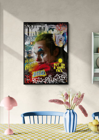Framed Joker - Ricardo Noble poster hanging above a dining table with flowers and colorful decor.