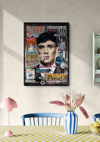 Framed Shelby - Ricardo Noble artwork on a dining room wall above a table with flowers and a pink lamp.