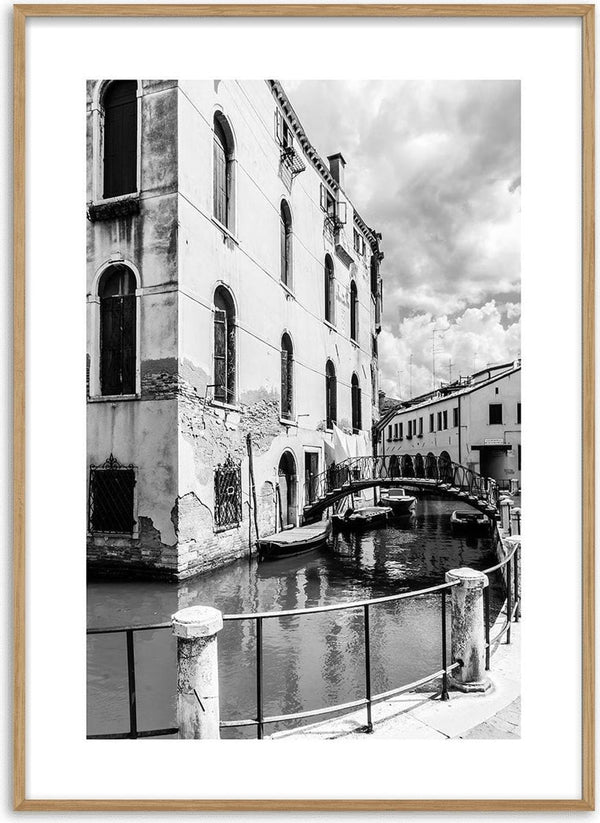 Black and white poster of a canal, bridge, and historic buildings in a European city.