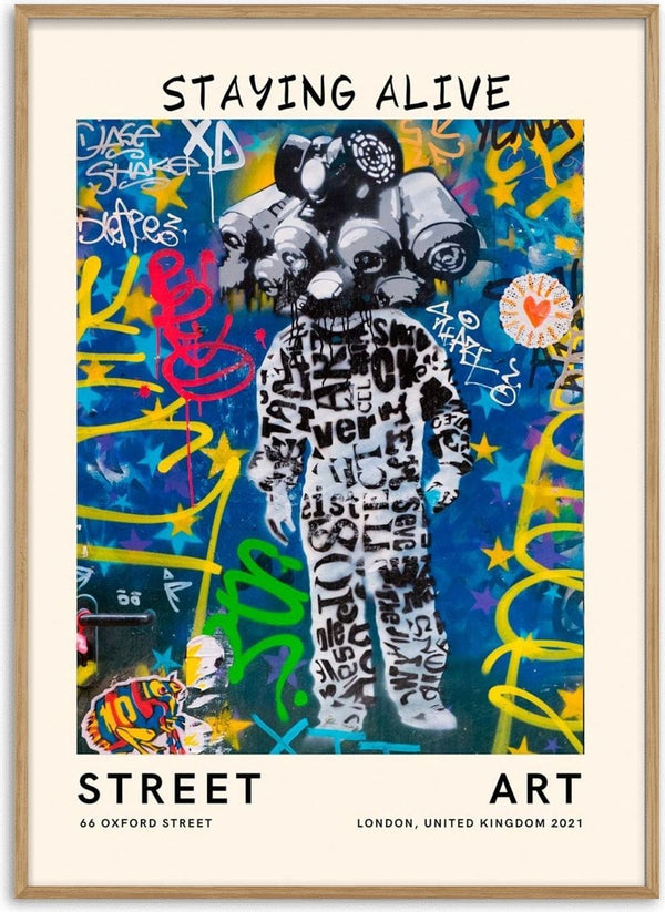 Colorful urban mural of a figure in black lettered suit, surrounded by vibrant graffiti. Text: Staying Alive.